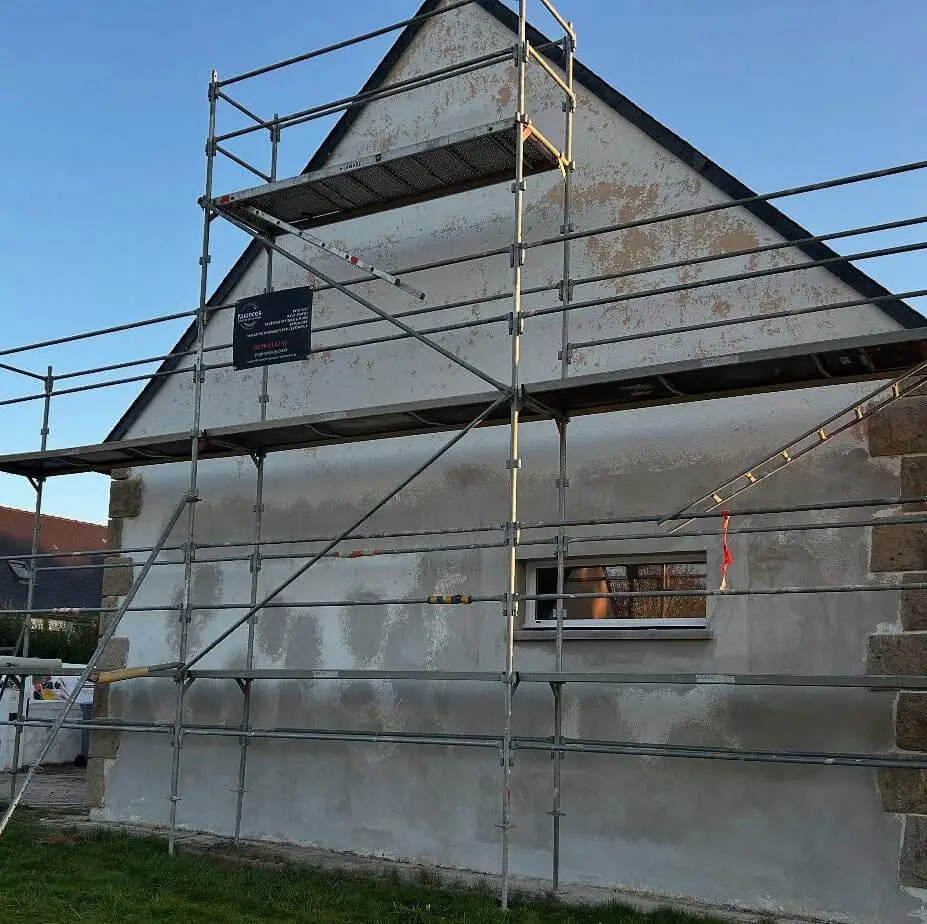 Entretien de façade Maison néo-bretonne sur échafaudage pendant la phase de nettoyage et d'entretien du pignon avant l'application de la peinture extérieure par l'entreprise Nuances peinture décoration.