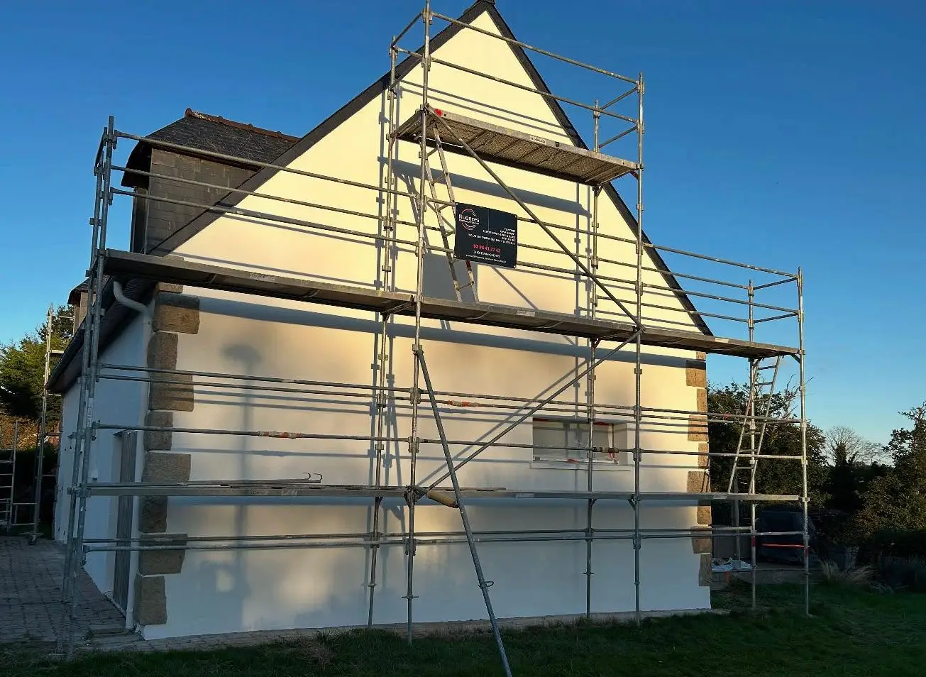 Maison individuelle en cours de rénovation avec application d'une peinture extérieure imperméable sur la façade par Nuances Peinture Décoration