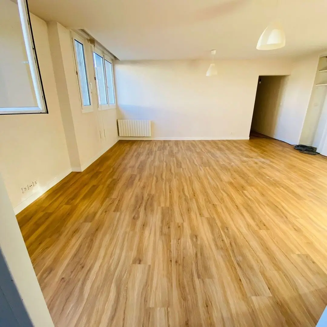 Rénovation complète d'un salon avec application d'une peinture intérieure blanche et pose d'un revêtement de sol stratifié aspect bois clair à Dinan.